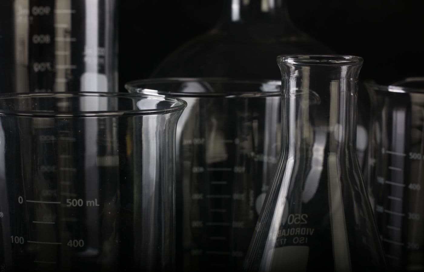 Beakers and volumetric flasks on a dark ground
